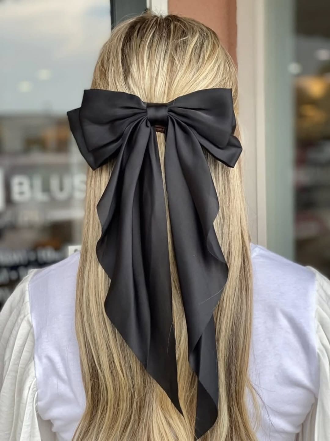 Long black satin ribbon bow — a statement piece